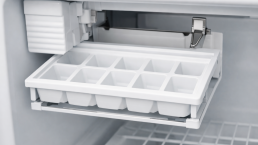 Empty clear plastic ice tray inside a freezer compartment with no ice cubes present, photorealistic view