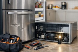 Technician inspecting a scratched refrigerator in a modern kitchen during a repair assessment