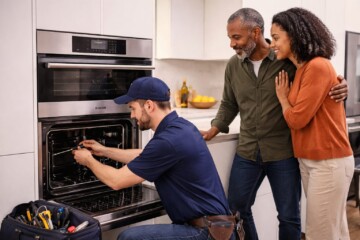 Homeowner discussing appliance warranty options with sales associate in modern kitchen showroom surrounded by Gaggenau
