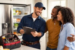 couple discussing extended warranty options with appliance sales associate in modern appliance showroom