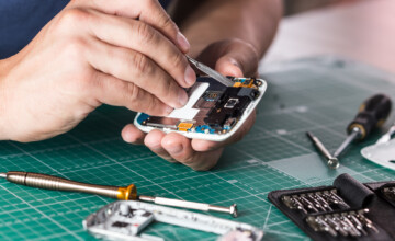 Man repairing broken smartphone, close up photo