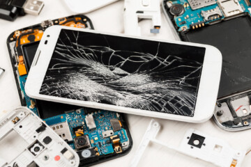 Cell phone with broken display among disassembled gadgets